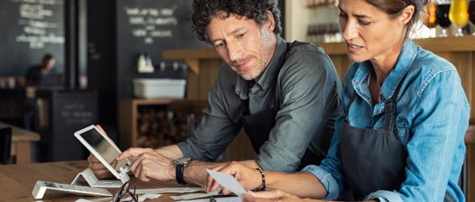 Business partners go through tax documents to determinate whether they need to apply for a filing extension.